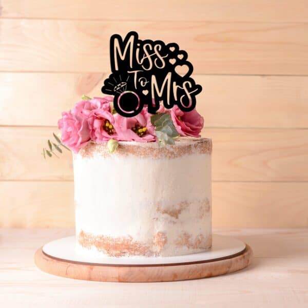 miss to mrs cake topper with engagement ring and heart design in black acrylic on a 1 tier cake.