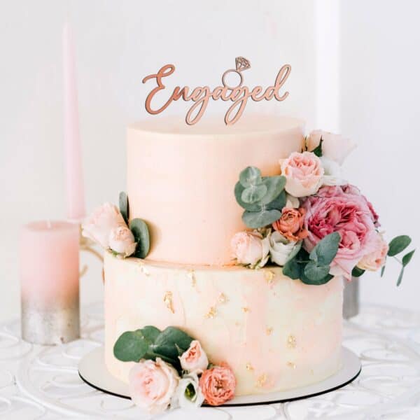 Custom-made engaged with diamond ring cake topper on a 2 tier blush engagement cake